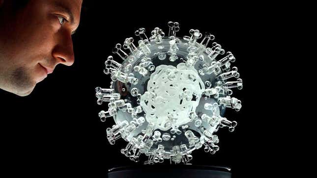 El artista británico Luke Jerram mirando su escultura de vidrio del virus SARS-CoV-2, titulada “coronavirus COVID-19”, en una foto tomada el 17 de marzo de 2020.