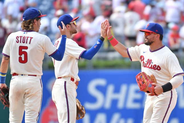 Aug 6, 2023; Philadelphia, Pennsylvania, USA; Philadelphia Phillies left fielder Kyle Schwarber (12) high fives shortstop Trea Turner (7) and second baseman Bryson Stott (5) as the celebrate win against the Kansas City Royals at Citizens Bank Park.