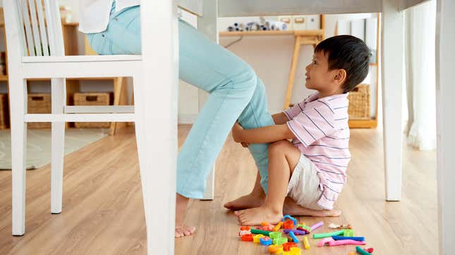 Young boy pulling on his mother's leg for attention