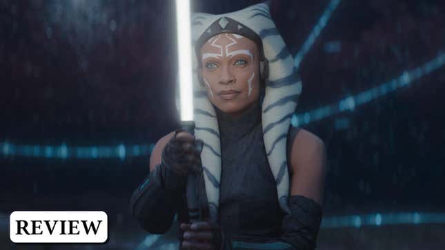 Ahsoka Tano stands with one white lightsaber ignited in front of her, ready to fight. 