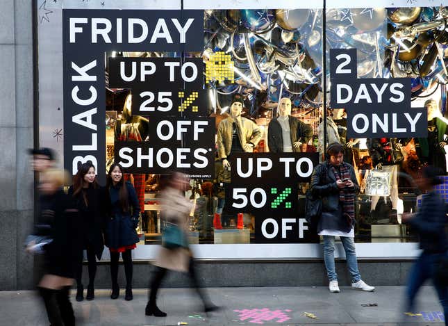 Shoppers walk past a store promoting "Black Friday" in London, Britain November 27, 2016. REUTERS/Peter Nicholls - LR1ECBR1B5AK2