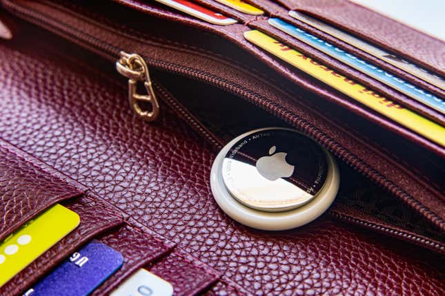 An apple AirTag inside a the zipper of a wallet.