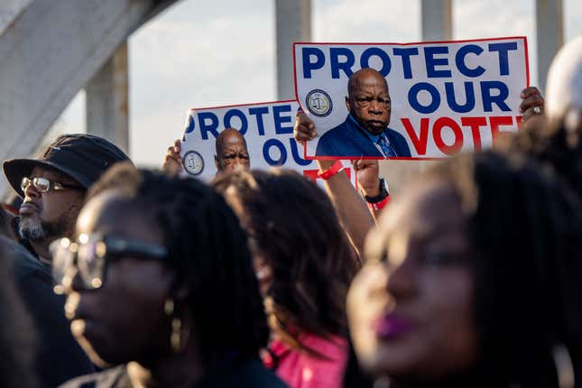 SELMA, ALABAMA - MARCH 06: People march across the Edmund Pettus Bridge with placards bearing the image of the late U.S. Rep. John Lewis, for whom the most recent voting rights bill is named, during commemorations for the 57th anniversary of “Bloody Sunday” on March 06, 2022 in Selma, Alabama.