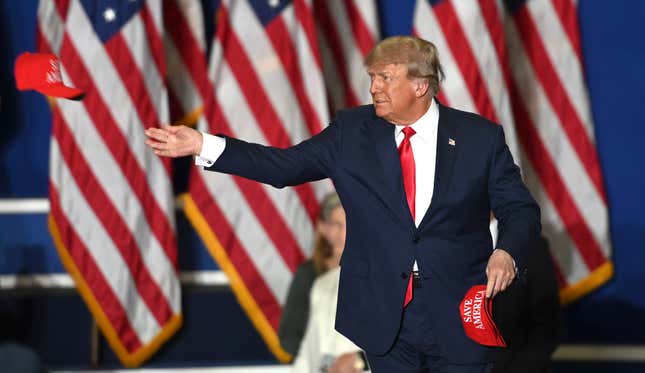 Former President Donald Trump tosses caps to the crowd as he steps onstage during a rally at the Macomb Community College Sports &amp; Expo Center in Warren, Mich., Saturday, Oct. 1, 2022.