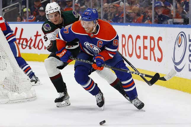 Mar 22, 2023; Edmonton, Alberta, CAN; Edmonton Oilers forward Connor McDavid (97) protects the puck from Arizona Coyotes defensemen Michael Kesselring (5) during the first period at Rogers Place.