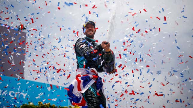 A photo of Sam Bird spraying champagne on the Formula E podium. 