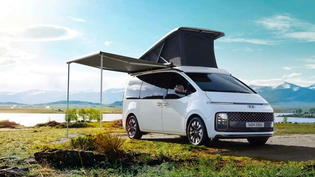 A photo of the Hyundai Staria Lounge Camper concept with its roof popped and awning out. 