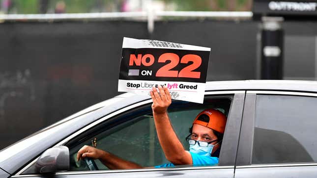 Driver holds sign saying "No on 22" in response to a California ballot measure known as Prop 22