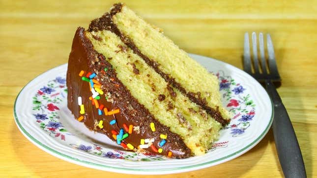 Slice of yellow cake with chocolate icing and sprinkles