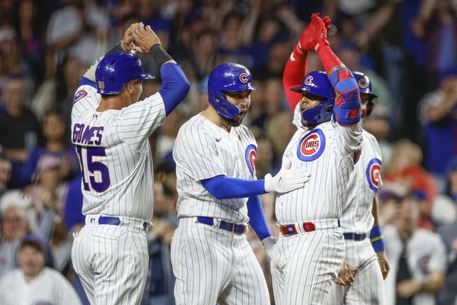 Apr 11, 2023; Chicago, Illinois, USA; Chicago Cubs center fielder Nelson Velazquez (right) celebrates with teammates as he crosses home plate after hitting a grand slam against the Seattle Mariners during the third inning at Wrigley Field.