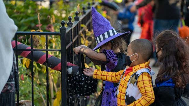 masked children trick or treaters receiving candy