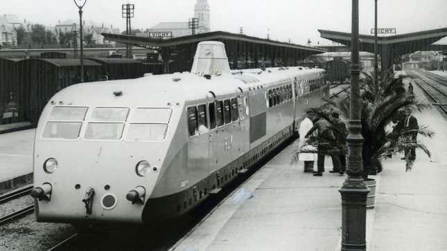 A black and white photo of a Bugatti train in a station. 