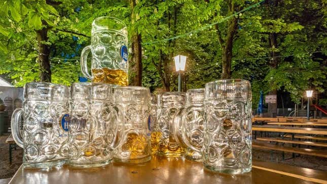 Stack of nearly empty beer steins in leafy beer garden