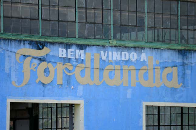 AVEIRO, BRAZIL - JULY 5: A welcome sign on the side of an abandoned factory building near the Fordlandia harbor on July 5, 2017 in Aveiro, Brazil. American industrialist Henry Ford negotiated the rights to 2.5 million acres of land from the Brazilian government to establish a rubber plantation. Construction started in 1926 with the hopes of employing 10,000 workers. By 1945 the project was considered a failure and the land was given back to the Brazilian government. 