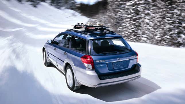 A blue Subaru wagon driving in the snow 