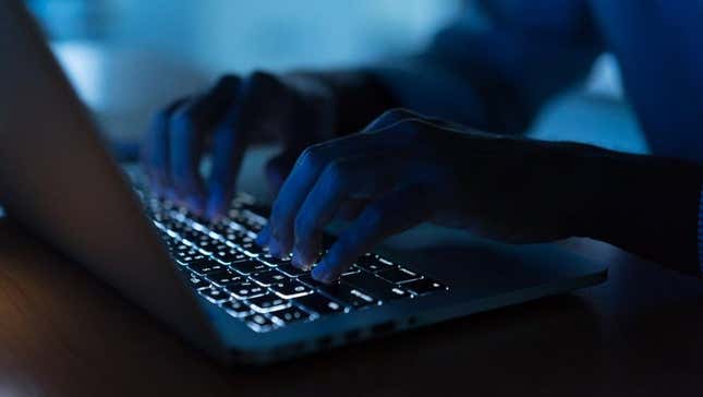 A person using a computer in the dark