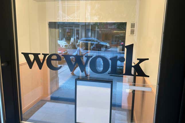 FILE - A sign for WeWork is displayed at the workspace-sharing office in the borough of Manhattan in New York, Aug. 9, 2023. WeWork will attempt renegotiate “nearly all” of its leases, the company said Wednesday, Sept. 6weeks after the workspace-sharing company sounded the alarm over its ability to stay in business. (AP Photo/Ted Shaffrey, File)
