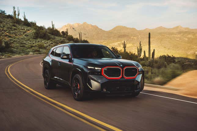 A black BMW XM Label Red with red accents drives in the desert.