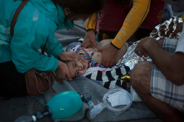 Paramedics and doctors try to revive a baby.