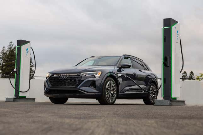 A 2024 Audi Q8 E-Tron SUV is charging at an Electrify America charging station.