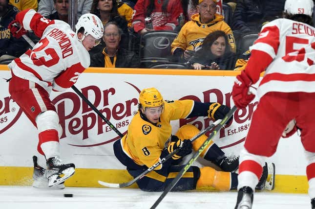 Mar 14, 2023; Nashville, Tennessee, USA; Nashville Predators center Cody Glass (8) plays the puck after being hit by Detroit Red Wings left wing Lucas Raymond (23) during the first period at Bridgestone Arena.