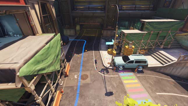 An overhead view of the Midtown map in Overwatch, showing off the rainbow-colored crosswalk and the newly painted SUV, formerly a cop car.