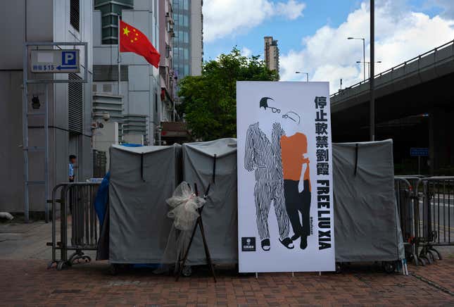 A banner displaying a sketch of late Chinese Nobel Peace laureate Liu Xiaobo and his wife Liu Xia is displayed outside the Chinese liaison office in Hong Kong on Saturday.