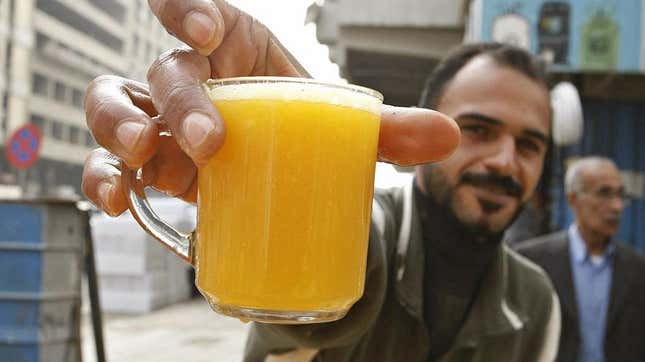 Man holding out glass of orange juice