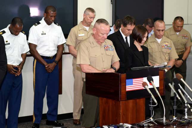US military officials observe a moment of silence to mourn the death of a 20-year-old Japanese woman, during a news conference in at Camp Foster in Okinawa, Japan, May 28, 2016.