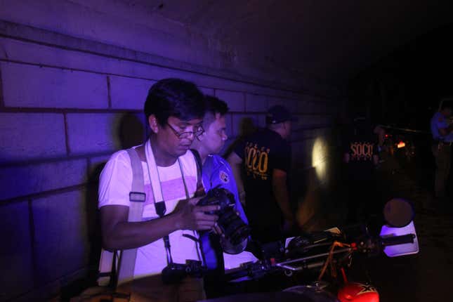Brother Jun reviews his photos after shooting a crime scene in Manila on February 21.