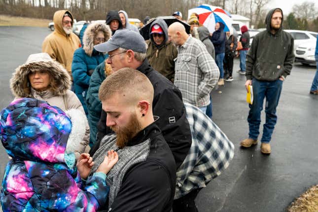 Neil Figley holds his daughter, Harlie, as they wait in line at the Norfolk Southern Assistance Center to collect a $1,000 check and get reimbursed for evacuation expenses on on February 17, 2023. 