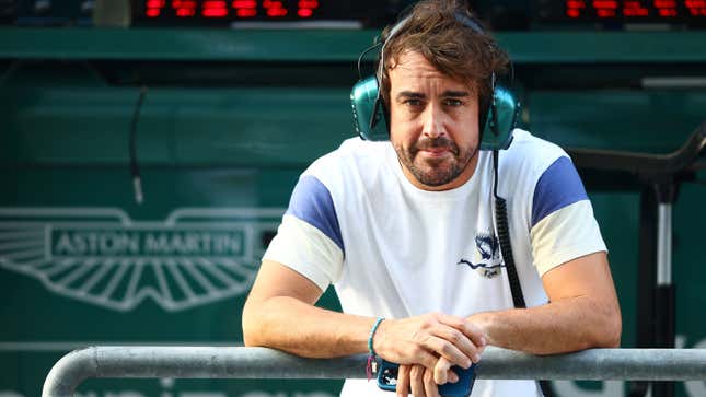 A photo of Fernando Alonso standing in the Aston Martin garage. 