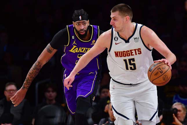 Dec 16, 2022; Los Angeles, California, USA; Denver Nuggets center Nikola Jokic (15) moves the ball ahead of Los Angeles Lakers forward Anthony Davis (3)  during the first half at Crypto.com Arena.
