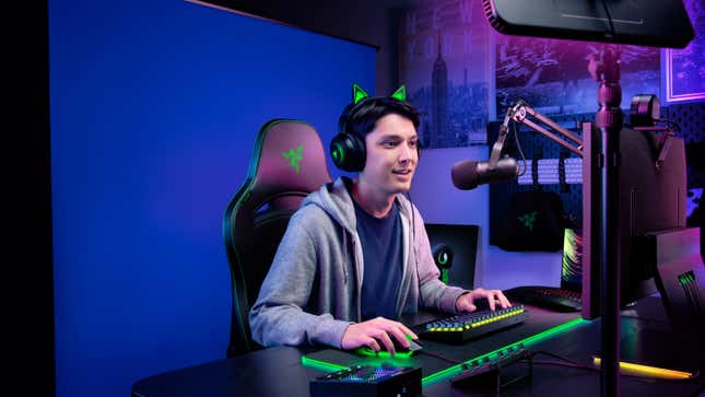 A streamer sitting in front of the Razer Blue Screen.