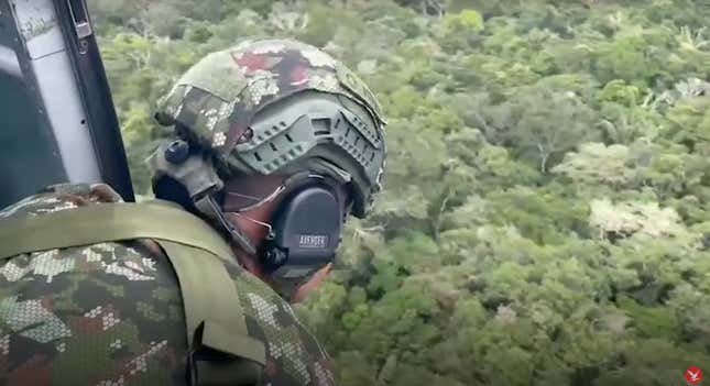A Colombia solider looks out over the thick jungle canopy of the Amazon from a helicopter.  