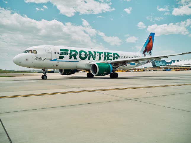 A Frontier Airlines plane taxis out from a terminal.