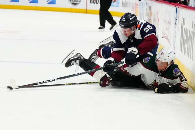 Mar 24, 2023; Denver, Colorado, USA; Arizona Coyotes center Barrett Hayton (29) and Colorado Avalanche right wing Logan O'Connor (25) reach for a loose puck in the third period at Ball Arena.