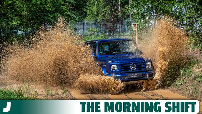 A photo of a blue Mercedes G Wagon driving through mud. 