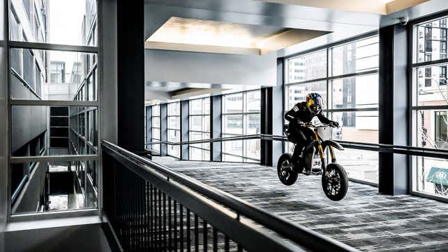 A photo of Aaron Colton riding an electric motorcycle inside. 
