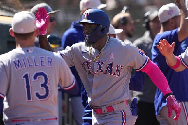 May 14, 2023; Oakland, California, USA; Texas Rangers right fielder Adolis Garcia (center) celebrates with teammates after hitting a grand slam home run against the Oakland Athletics during the eighth inning at Oakland-Alameda County Coliseum.