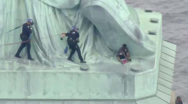 Patricia Okounou being arrested by police rescuers on the Statue of Liberty