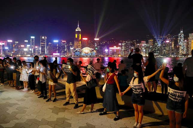 Demonstrators link hands as they gather at the Tsim Sha Tsui waterfront in Hong Kong.