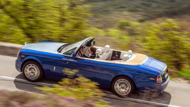 A photo of a blue Rolls Royce Phantom Drophead with its roof down. 