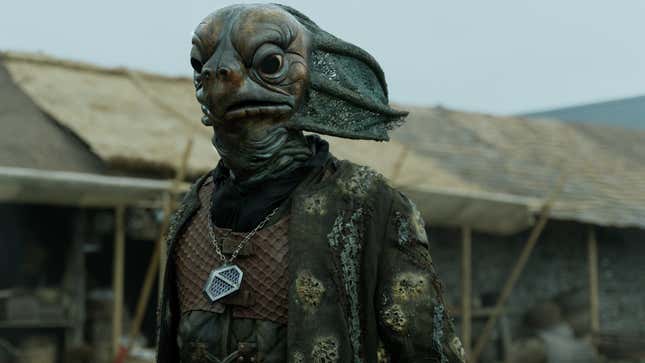 A Sea Devil from Doctor Who, standing in the middle of a village. 
