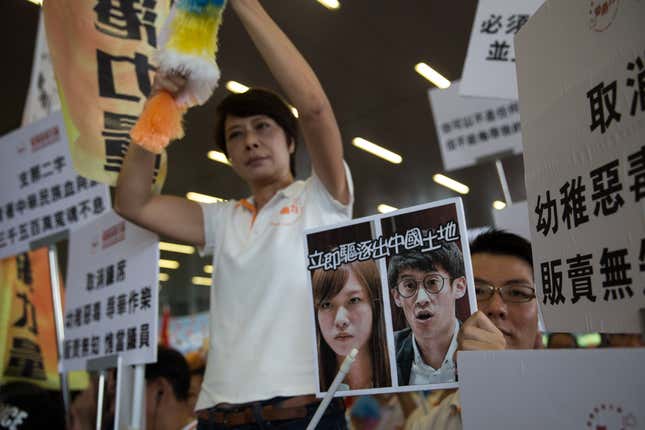 Beijing supporters hold pictures of Baggio Leung and Yau Wai-ching on a placard that reads “Get out of Chinese land immediately” during a protest outside the Legislative Council in Hong Kong, 19 October 2016.