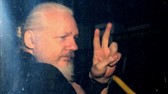 WikiLeaks founder Julian Assange gestures to photographers from a police vehicle while arriving at Westminster Magistrates court in April 2019 in London, England.