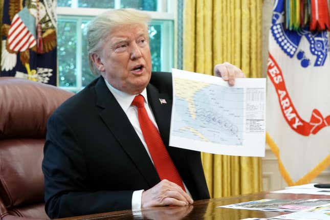 Donald Trump holding hurricane projection map