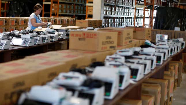 An electoral worker seals electronic ballot boxes in Curitiba.