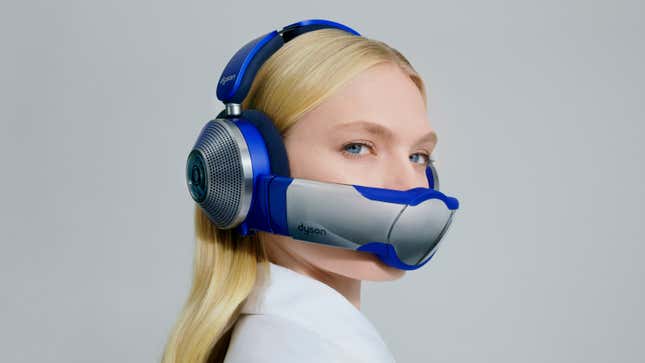 A user wearing the Dyson Zone headphones with the filtration visor attached against a gray backdrop.