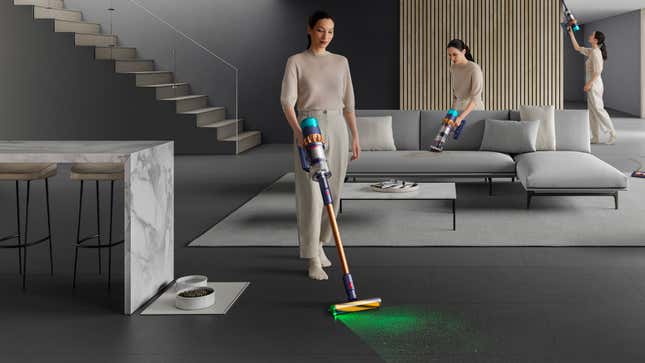 Varias personas usan la aspiradora inalámbrica Dyson Gen5detect para limpiar varias partes de una casa, incluido el piso, un sofá y un área más alta de difícil acceso.